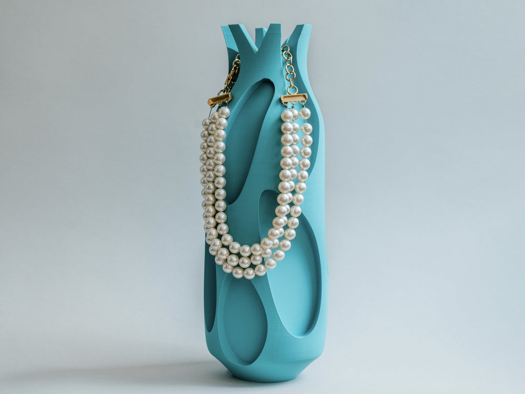 Minimalistische Vase mit Perlenkette in türkis
