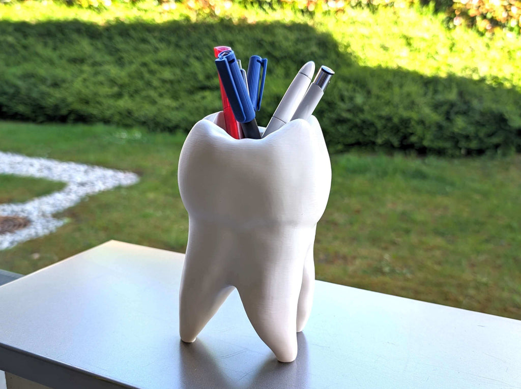 Zahn Dekogefäß mit Stiften im Freien bei Sonnenschein